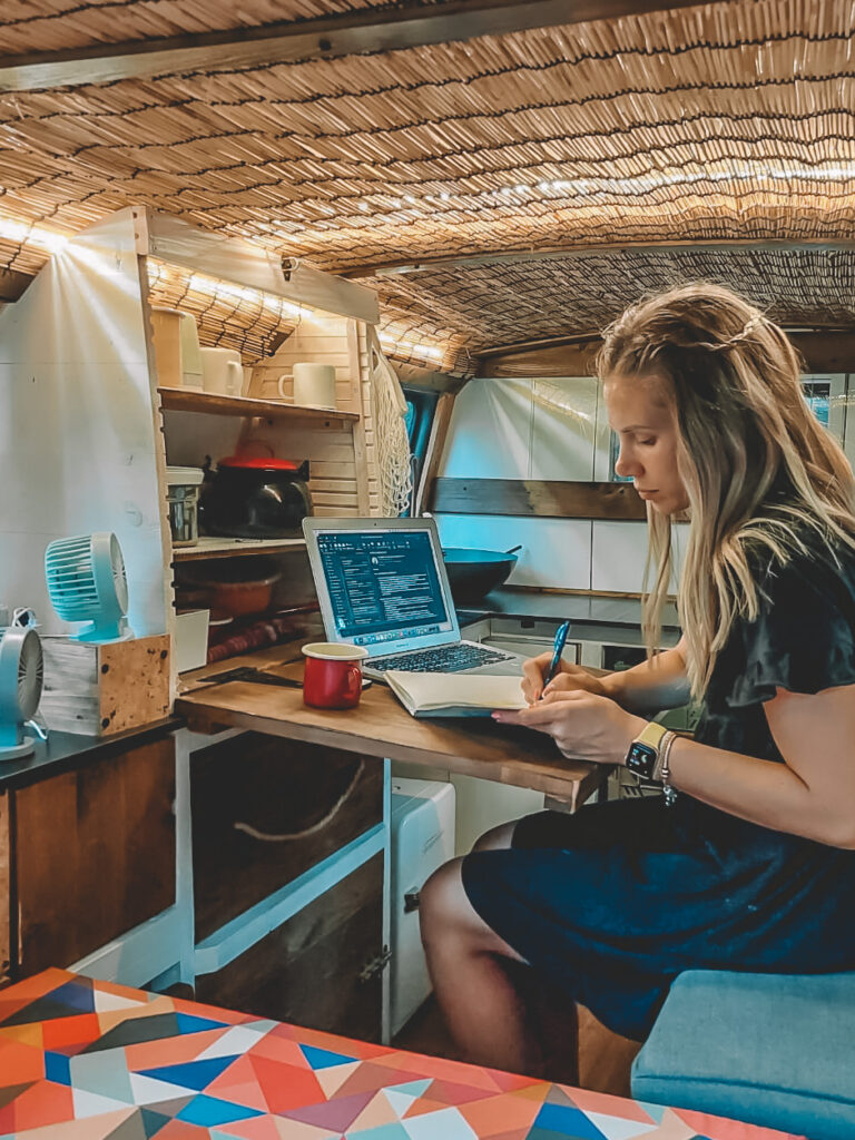 Devojka radi na laptopu u kamperu